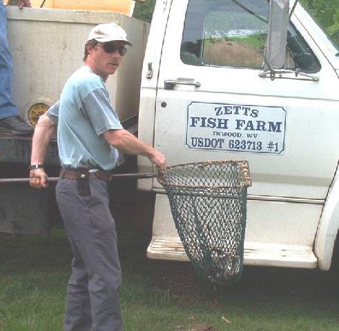 Gary carrying a net full of catfish from the truck
